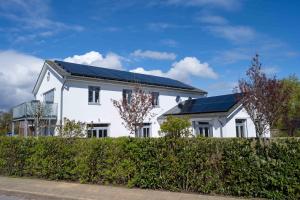 ein weißes Haus mit Sonnenkollektoren darauf in der Unterkunft Haus Lillemor Wohnung 2 in Wyk auf Föhr