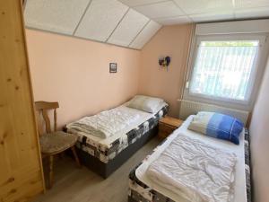 1 dormitorio con 2 camas y ventana en Ferienbungalow Lais - Seite 1, en Loissin