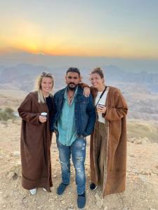 un grupo de tres personas de pie en la cima de una montaña en Petra Desert Dream Hotel, en Wadi Musa