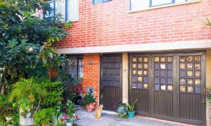 una casa de ladrillo con dos puertas de garaje y plantas en Habitación semi urbana, en Duitama