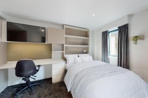 a bedroom with a bed and a desk and a computer at Premium Studios at Chapter Westminster in London minutes away from The Big Ben in London