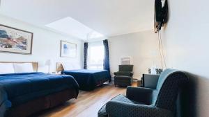 1 dormitorio con cama, sofá y sillas en Commons Inn en Halifax