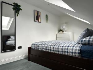1 dormitorio con cama y espejo en Private self-contained flat with shared entrance en Londres