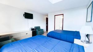 Un dormitorio con una cama azul y una silla. en Commons Inn, en Halifax 20 fotos más