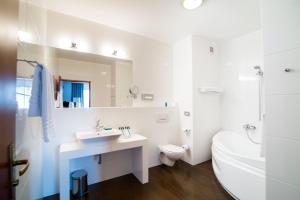 a bathroom with a sink, toilet and bathtub at Hotel Hanza in Gdańsk