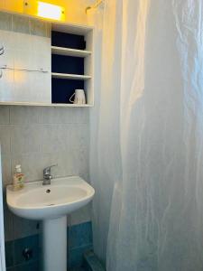 a bathroom with a sink and a shower curtain at Anemomylos apartment sea view in Pefkohori