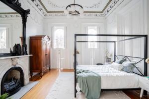 Decadent Luxury - Covington Condo في كوفينغتون: غرفة نوم بيضاء مع سرير ومدفأة