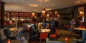 a restaurant with people sitting at tables and a fireplace at Clayton Hotel Leopardstown in Leopardstown