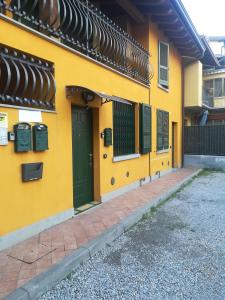 a yellow building with a green door and windows at B&B Luna - Osio Sopra in Osio Sotto