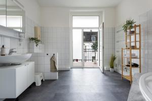 ein weißes Badezimmer mit Waschbecken und Badewanne in der Unterkunft stayVision FS43 Wohnung 5 - 3 Schlafzimmer - 8 Gäste - 2 Balkone - top WLAN in Wuppertal + 9 Fotos