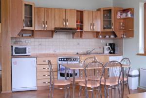 a kitchen with wooden cabinets and a table and chairs at Apartment Maat in Donovaly