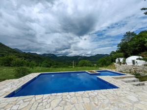 una piscina su un patio con montagne sullo sfondo di ZEN Relaxing Village 