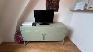 a television on top of a dresser in a room at Studio Cosy Av De Charles De Gaulle 'Neuilly' in Neuilly-sur-Seine