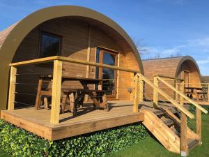 a cabin with a wooden deck and a table at Eco-friendly Cabins Cabin 3 in Norton Disney