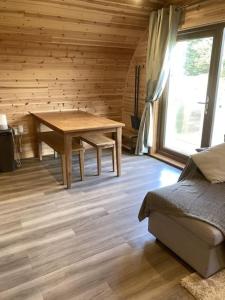 a wooden room with a wooden table and a bed at Eco-friendly Cabins Cabin 3 in Norton Disney +7 photos