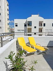 dos sillas amarillas sentadas en la parte superior de un edificio en Algarve Sol Beach House, en Quarteira