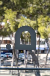 a metal sign with the letter q on a street at Onmood Cala Ratjada - New Opening 2024 in Cala Ratjada