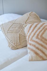 a bed with two pillows on top of it at Onmood Cala Ratjada - New Opening 2024 in Cala Ratjada
