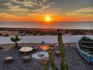 阿加迪尔Riad & Restaurant Ocean Beach Douira的海上的日落,火坑