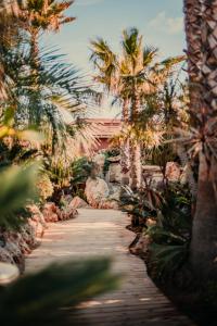 a wooden path in a garden with palm trees at Toison D'or in Saint-Tropez