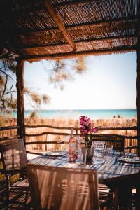 a table with glasses and a vase with flowers on it at Toison D'or in Saint-Tropez