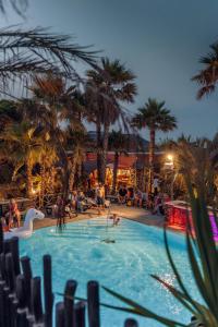a pool with palm trees and people playing in it at Toison D'or in Saint-Tropez