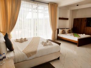 a bedroom with two beds and a large window at Serenemo Eco Resort in Pundaluoya