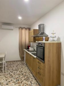 a kitchen with wooden cabinets and a stove top oven at Da Peppino e Nicchella in Marina di Camerota