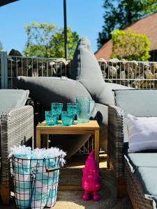 a pink cat sitting on a table next to glasses at Sievershof Poolloft in Wietzendorf
