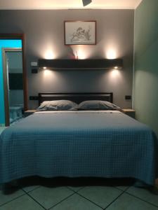 a bedroom with a large bed with a blue comforter at B&B Luna - Osio Sopra in Osio Sotto