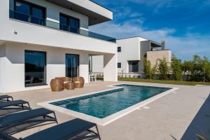 een villa met zwembad en huis bij Villa Karlo ZadarVillas in Glavan
