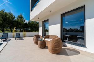 een patio met stoelen en een groot raam bij Villa Karlo ZadarVillas in Glavan +36 foto's