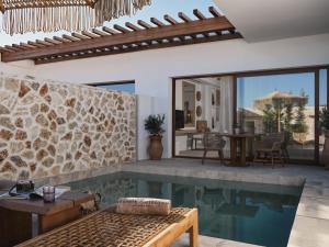 a villa with a swimming pool and a patio at Lesante Cape Resort & Villas - The Leading Hotels of the World in Akrotiri