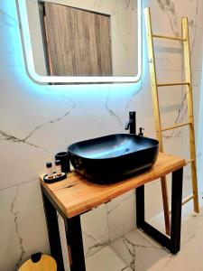 a black sink on a wooden table with a mirror at Philoxenia Guest Studio in Himare