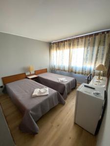 ブラガンサにあるSão Roque Hotel & Suitesのベッドルーム1室(ベッド2台、鏡付きテーブル付)