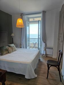 a bedroom with a bed and a chair and a window at Maison Bella Vista in Cagnano