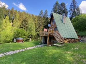 een hut in het bos met een groen dak bij Chalet Kosorky in Čadca