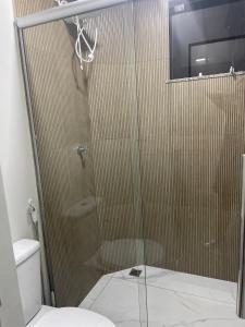 um chuveiro com uma porta de vidro na casa de banho em Apartamento na Batista Campos 02 quartos em Belém