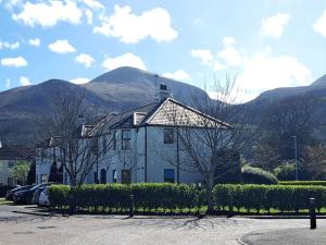 a white building with a mountain in the background at Donard View, Newcastle in Newcastle
