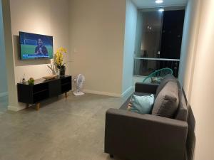 a living room with a couch and a flat screen tv at Apartamento na Batista Campos 02 quartos in Belém