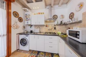 メストレにあるTalaminiのキッチン(白いキャビネット、洗濯機、乾燥機付)