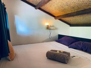 a bedroom with a bed with a brown pillow on it at Studio On Air in Gili Islands