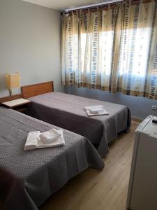ブラガンサにあるSão Roque Hotel & Suitesのホテルルーム内のベッド2台(タオル付)