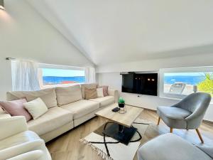 sala de estar con sofá blanco y TV en Deluxe Villa No.10 - Rooms & Apartments en Mandre