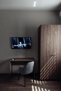 a room with a desk and a television on a wall at Nesvit Hotel in Kyiv
