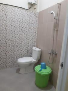 a bathroom with a toilet and a shower and a green trash can at Villa risky A11 in Tlekung +8 photos