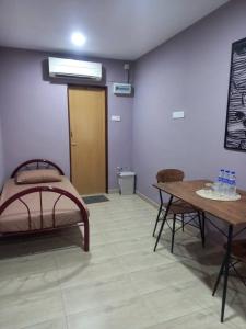 a room with a bed and a table and a door at Tambun Homestay in Tambun