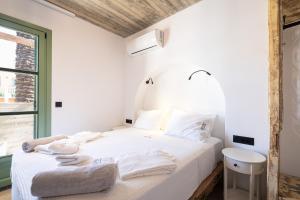 um quarto com uma cama branca e toalhas em Casa del Sol Suites in Ilha de Rhodes