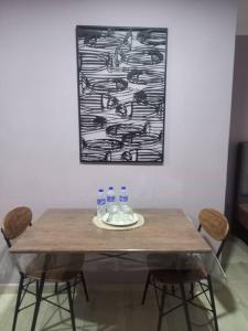 a dining room table with chairs and a painting at Tambun Homestay in Tambun