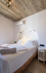 a bedroom with a white bed with a wooden ceiling at Casa del Sol Suites in Rhodes Town
